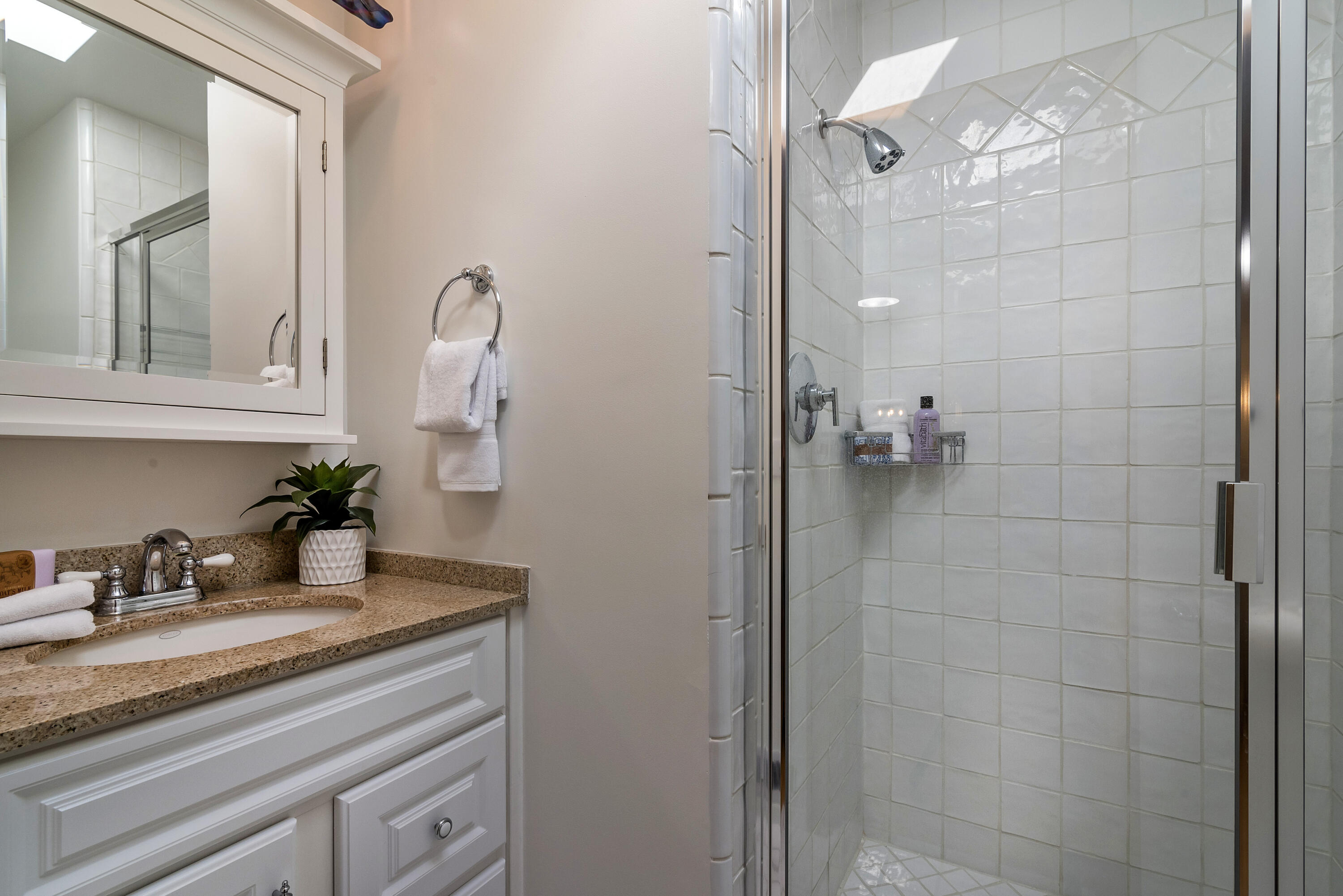 548 San Ysidro Road, Unit 1 Santa Barbara, CA 93108 - Photo 14 of 20 a bathroom with a granite countertop sink a mirror and shower