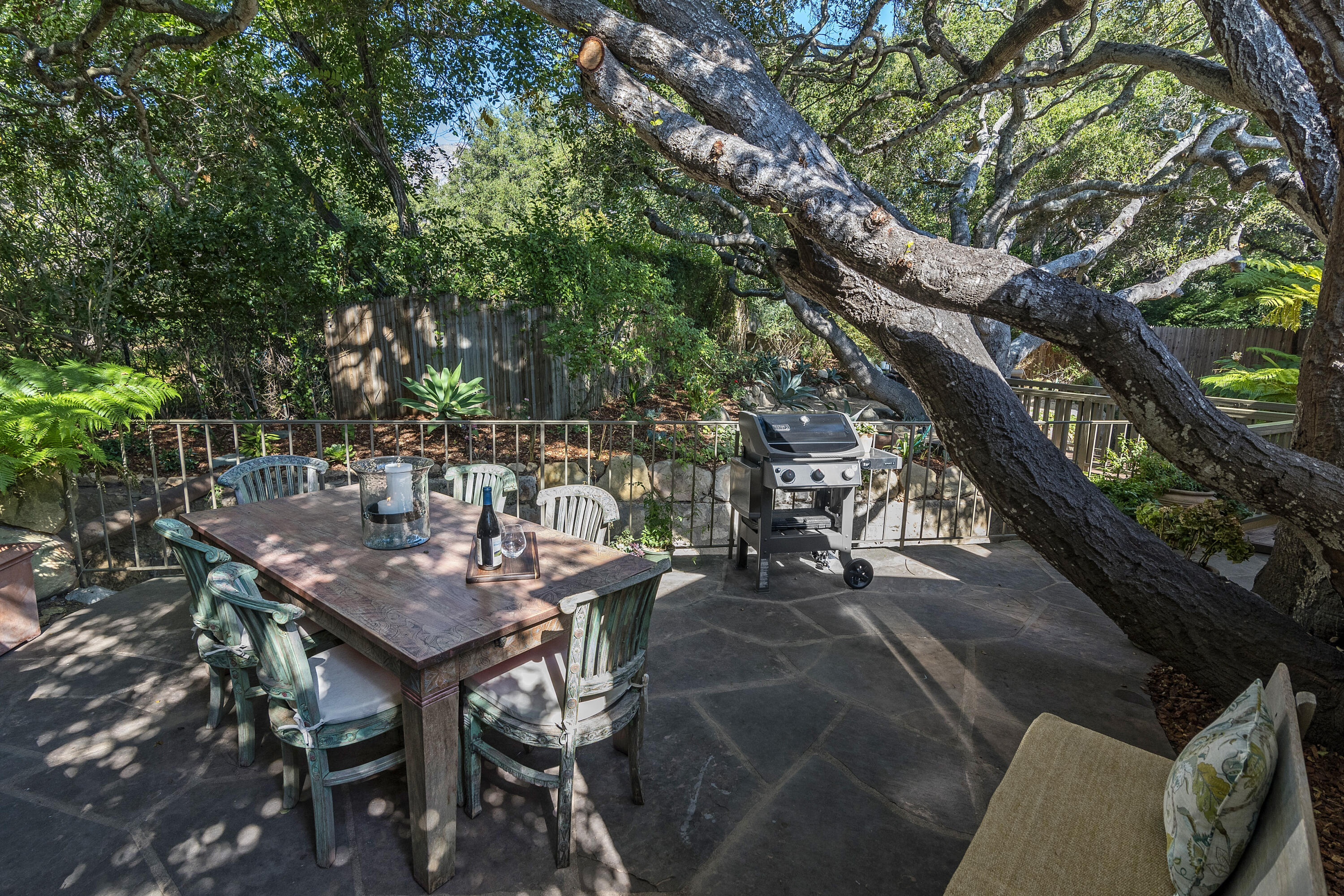 548 San Ysidro Road, Unit 1 Santa Barbara, CA 93108 - Photo 19 of 20 a view of a backyard with table and chairs potted plants and large tree
