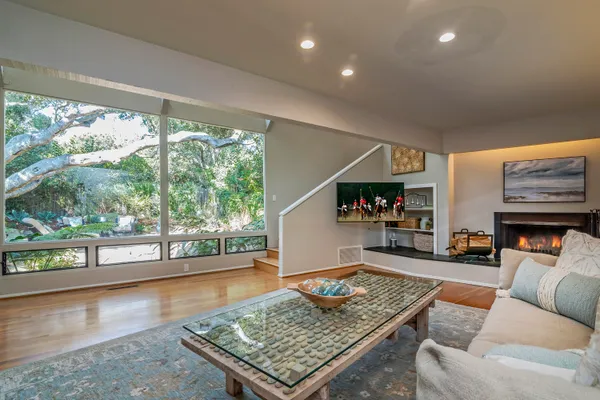 a living room with fireplace furniture and a large window