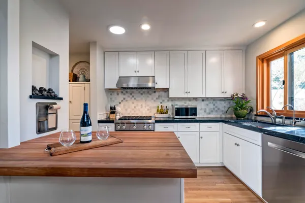 a kitchen with kitchen island granite countertop a sink cabinets and window
