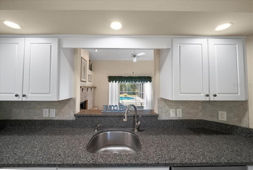 9660 Southwest 196th Avenue Road Dunnellon, FL 34432 - Photo 62 of 67 a kitchen with granite countertop a sink a window and cabinets