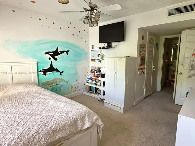 a bedroom with a bed and a flat tv screen on the dresser