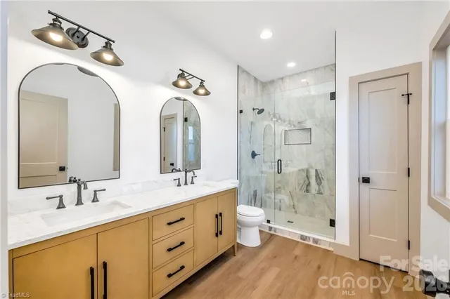 a bathroom with a double vanity sink mirror and shower