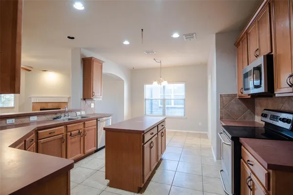 a kitchen that has a sink a stove top oven and cabinets