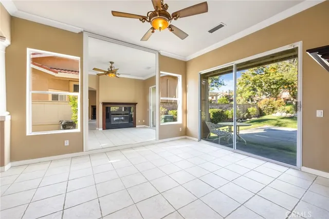 a view of an empty room with window and kitchen view