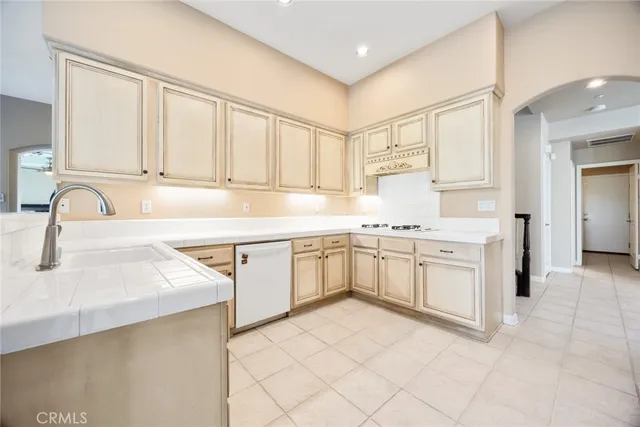 a kitchen with white cabinets sink and stove