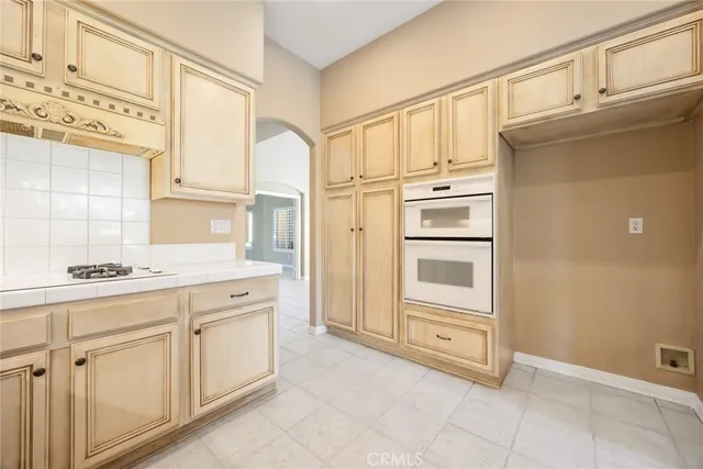 a kitchen with white cabinets and white appliances