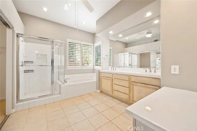 a spacious bathroom with a granite countertop sink a mirror a bathtub and next to a window