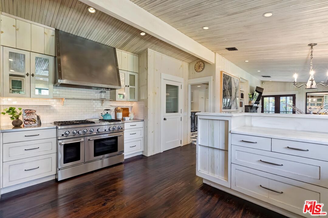13240 Chalon Road Los Angeles, CA 90049 - Photo 16 of 46 a kitchen with stainless steel appliances granite countertop a stove and a sink
