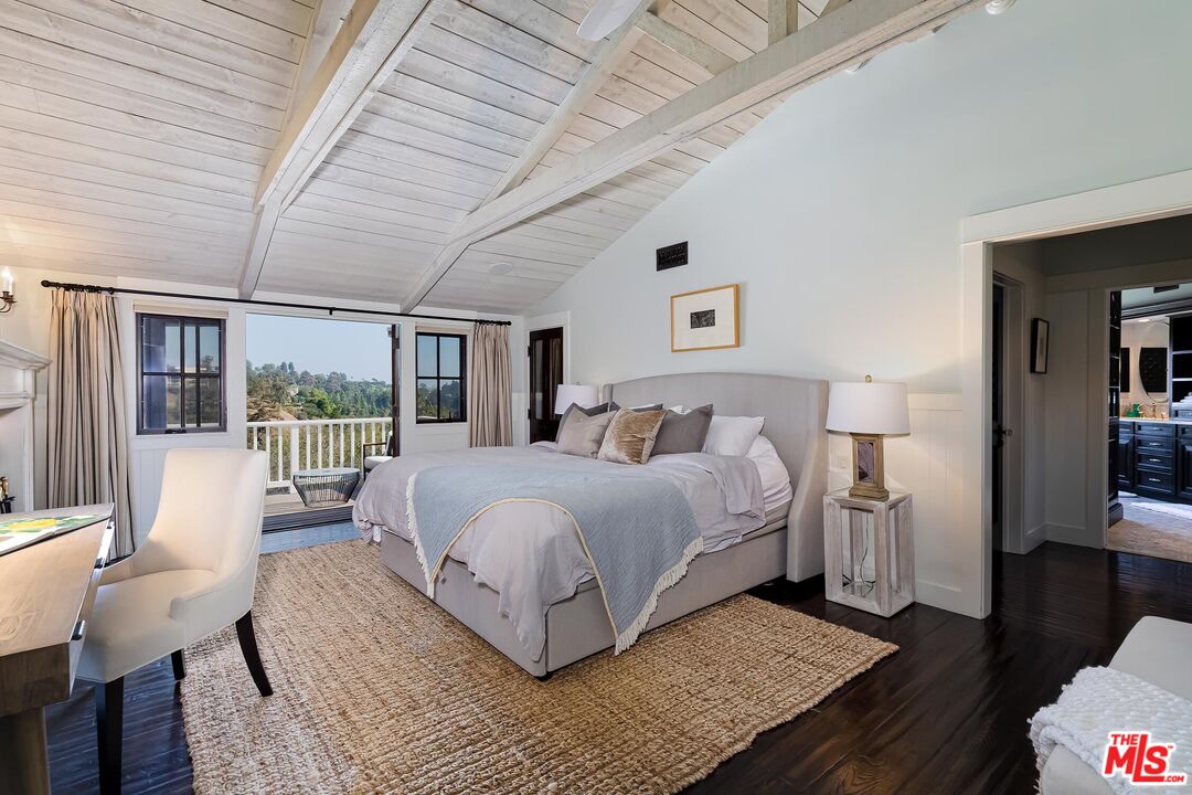 13240 Chalon Road Los Angeles, CA 90049 - Photo 22 of 46 a bedroom with a bed wooden floor and large window