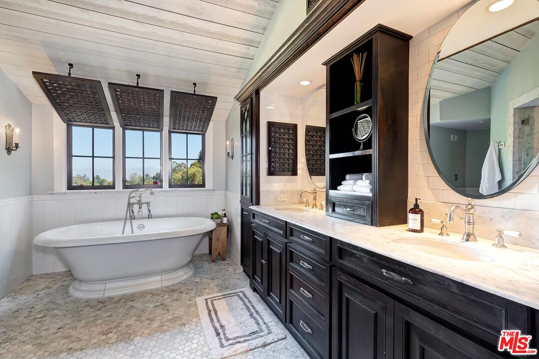 13240 Chalon Road Los Angeles, CA 90049 - Photo 25 of 46 a spacious bathroom with a bathtub sink and mirror