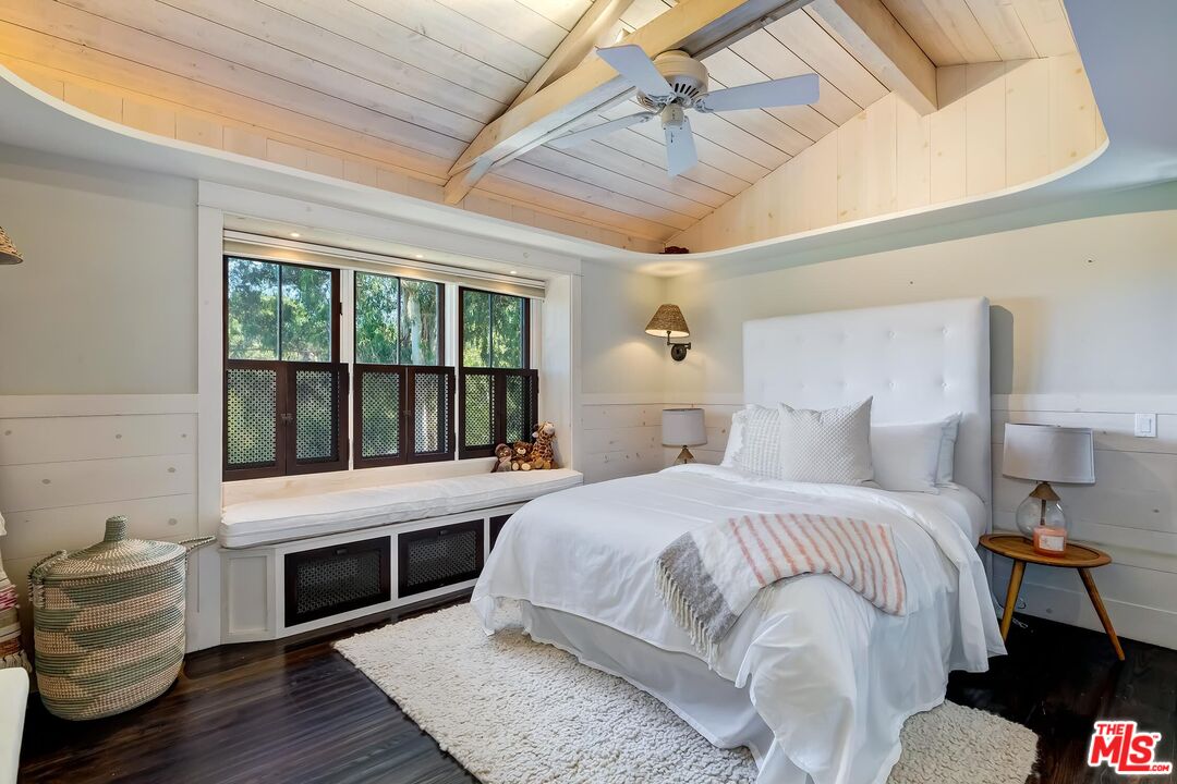 13240 Chalon Road Los Angeles, CA 90049 - Photo 26 of 46 a bedroom with a bed and a large window with wooden floor