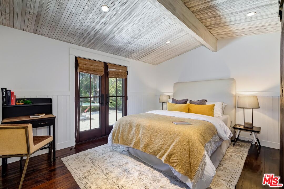 13240 Chalon Road Los Angeles, CA 90049 - Photo 28 of 46 a bedroom with a bed a dresser and wooden floor
