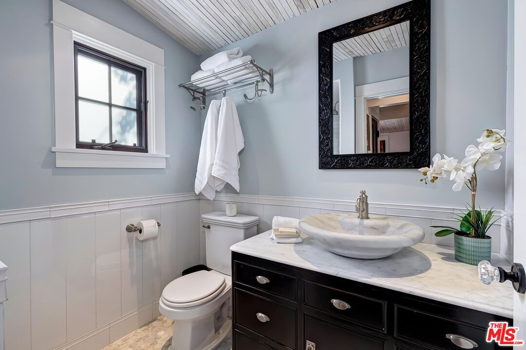 13240 Chalon Road Los Angeles, CA 90049 - Photo 29 of 46 a bathroom with a toilet a sink and a mirror