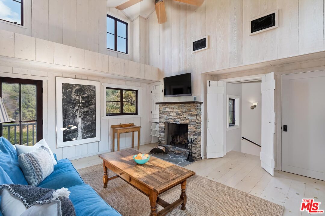 13240 Chalon Road Los Angeles, CA 90049 - Photo 34 of 46 a living room with furniture a flat screen tv and a fireplace