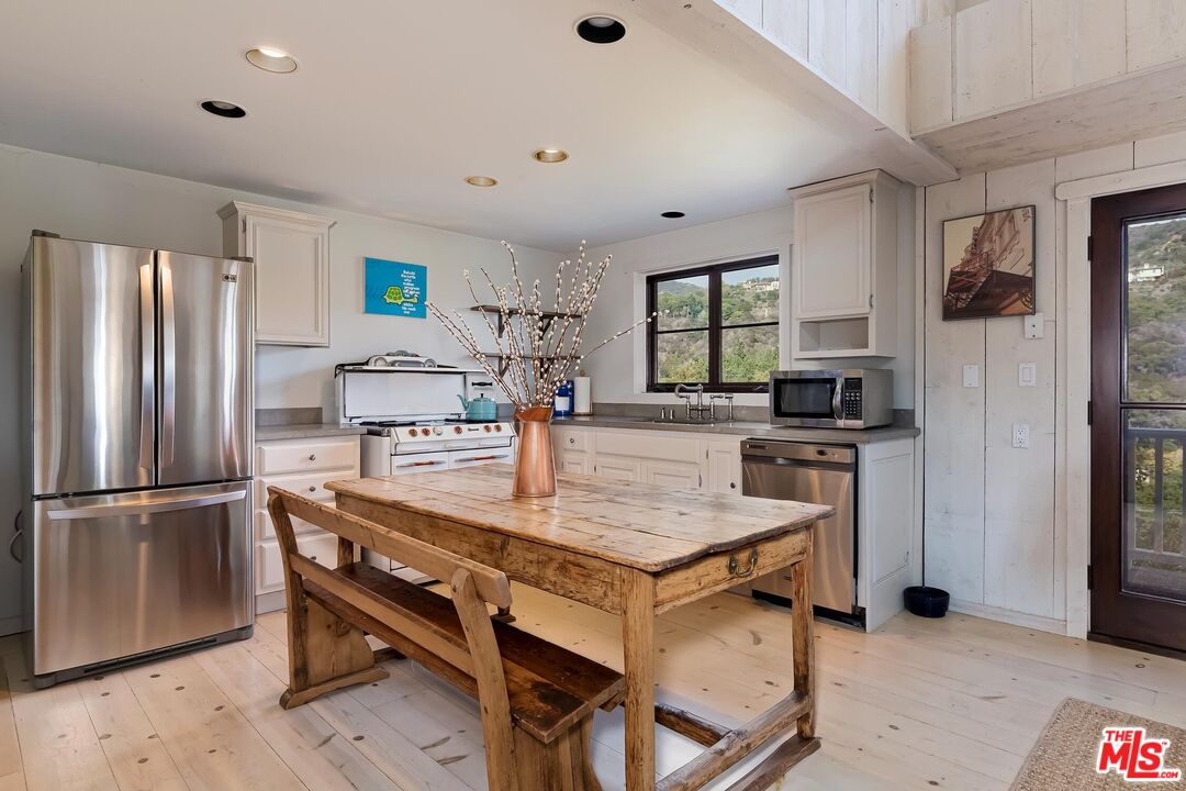 13240 Chalon Road Los Angeles, CA 90049 - Photo 36 of 46 a kitchen with stainless steel appliances granite countertop a sink refrigerator and microwave