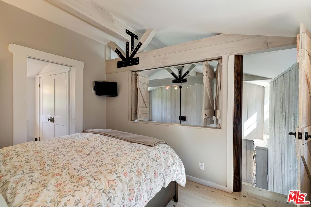 13240 Chalon Road Los Angeles, CA 90049 - Photo 38 of 46 a bedroom with a large bed and a window