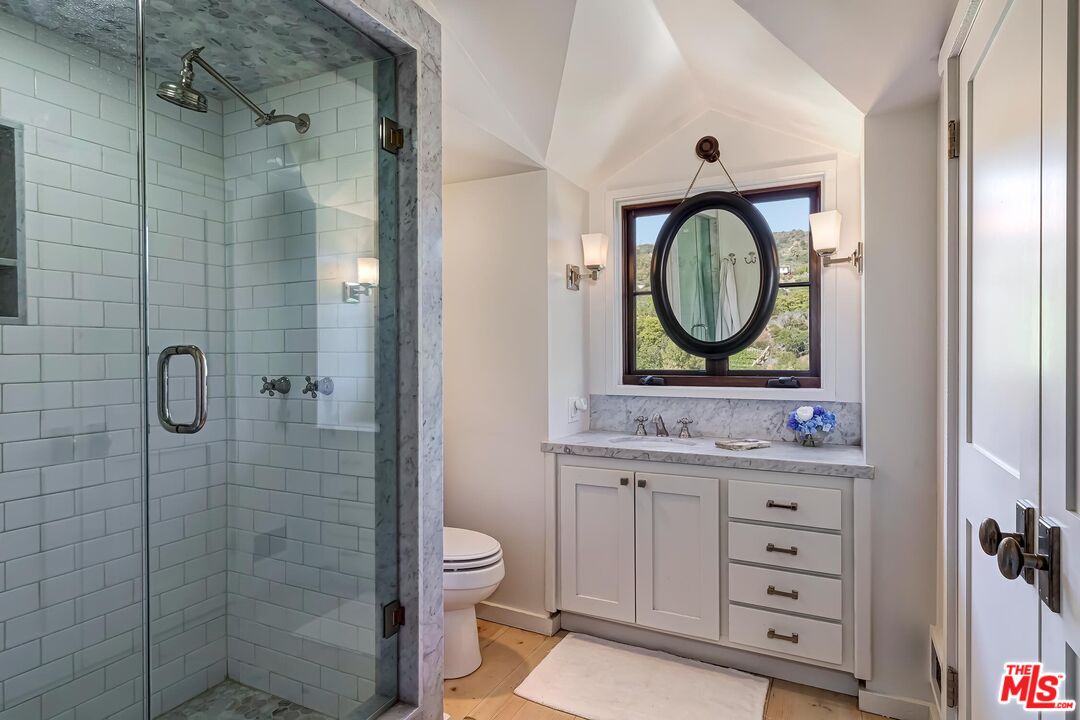 13240 Chalon Road Los Angeles, CA 90049 - Photo 39 of 46 a bathroom with a toilet sink vanity and shower