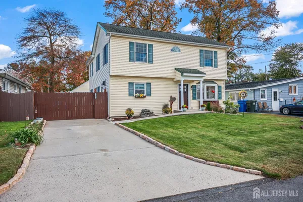 a front view of a house with a yard and potted plants