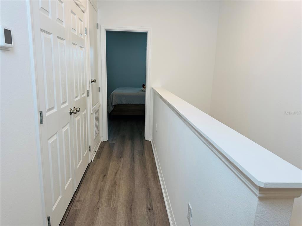 1301 Wycliffe Way St. Cloud, FL 34771 - Photo 11 of 50 a view of a hallway with a white walls and wooden floor