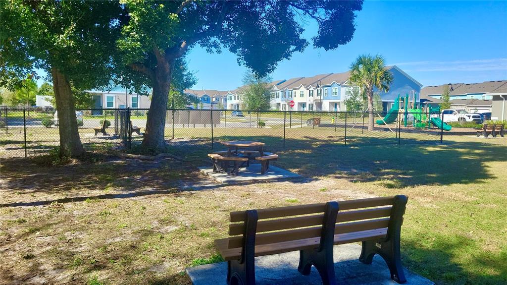 1301 Wycliffe Way St. Cloud, FL 34771 - Photo 43 of 50 a view of a lake with a bench and trees around