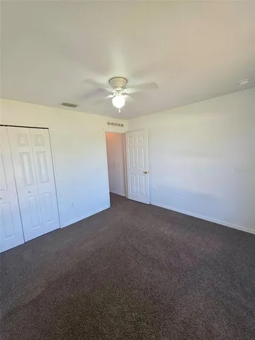 an empty room with chandelier fan