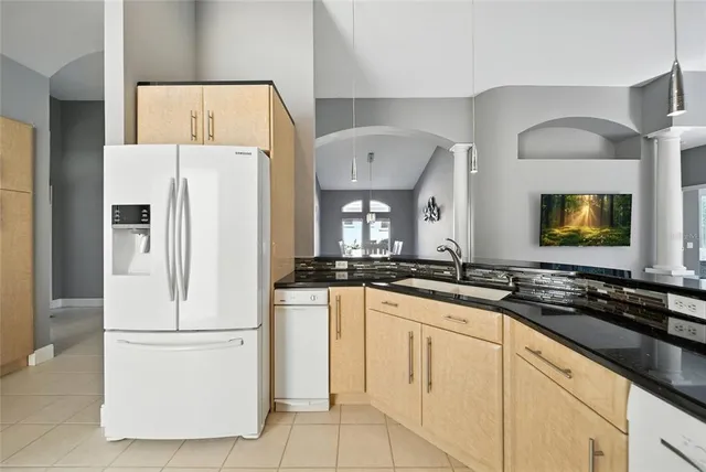 a kitchen with granite countertop white cabinets and white appliances