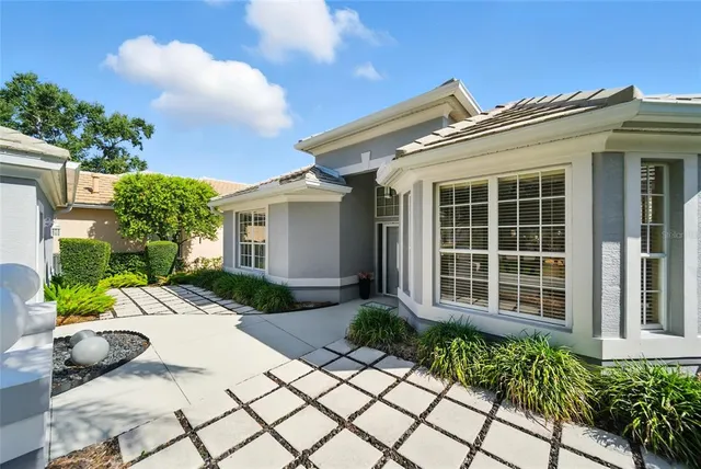 a view of a house with potted plants and a bench