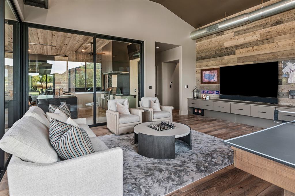 988 English Road Rockwall, TX 75032 - Photo 27 of 40 a living room with furniture a flat screen tv and a floor to ceiling window