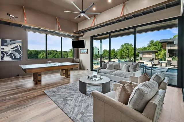 a living room with furniture a ceiling fan and a floor to ceiling window