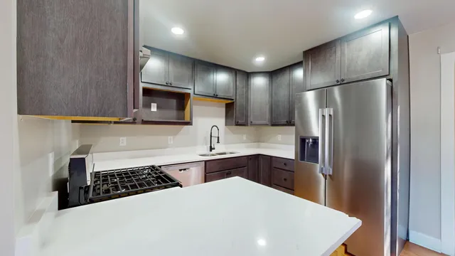a kitchen with stainless steel appliances a refrigerator sink and stove