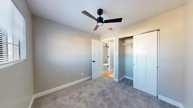 a view of a hallway with a ceiling fan