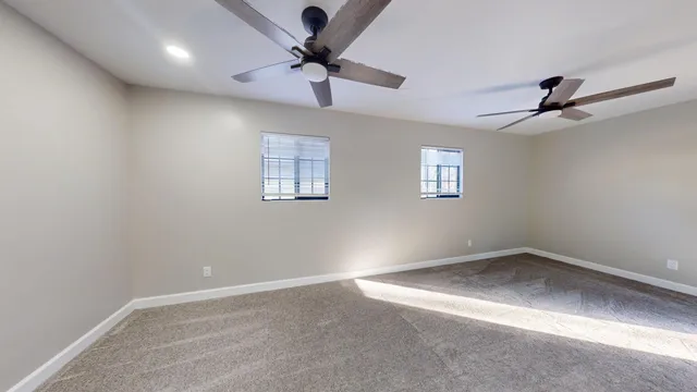 an empty room with a window and a fan