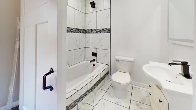 a bathroom with a granite countertop toilet a sink and bathtub