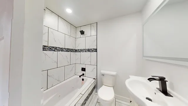 a bathroom with a toilet a sink and bathtub