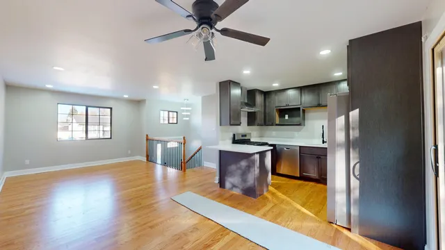 a kitchen with stainless steel appliances granite countertop a refrigerator a stove top oven a sink dishwasher and a refrigerator