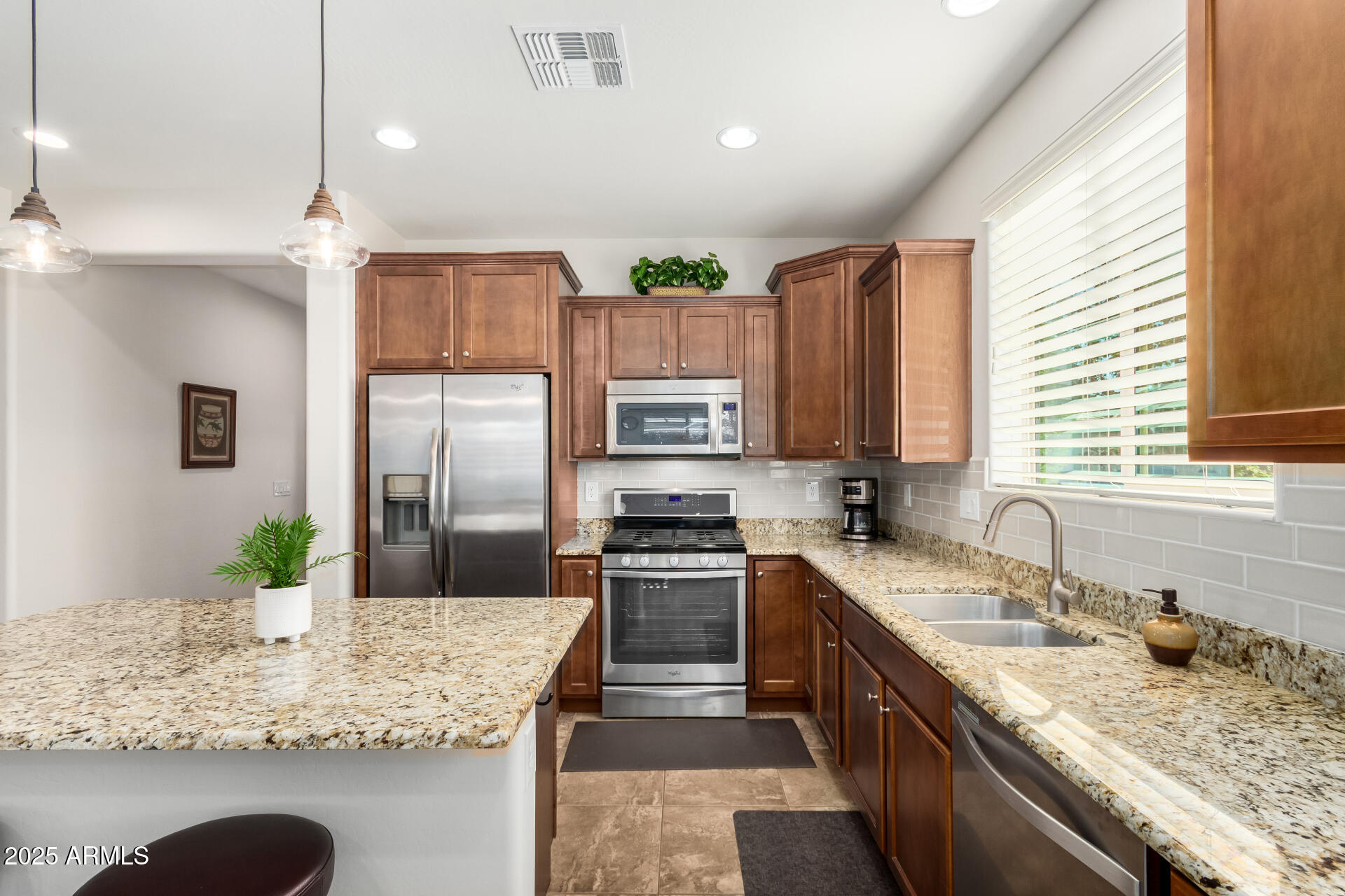 7253 West Cinder Brook Way Florence, AZ 85132 - Photo 19 of 72 a kitchen with kitchen island granite countertop a sink stainless steel appliances and cabinets