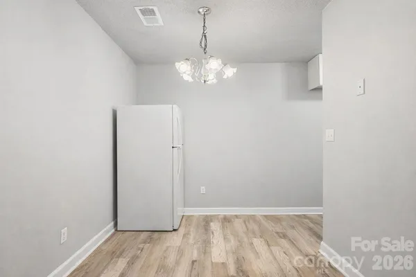 a view of a room with wooden floor and chandelier