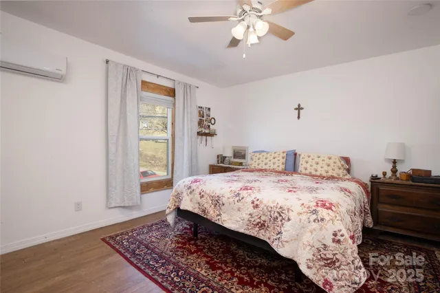 a bedroom with a bed rug and wooden floor