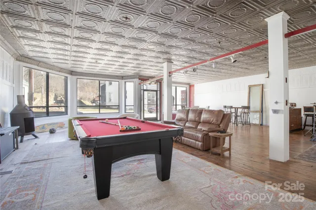 a room with pool table and windows