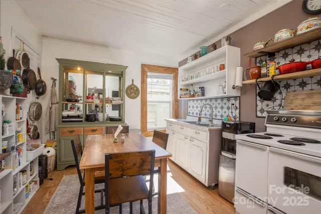 a kitchen with stainless steel appliances a stove a sink dishwasher and cabinets with wooden floor