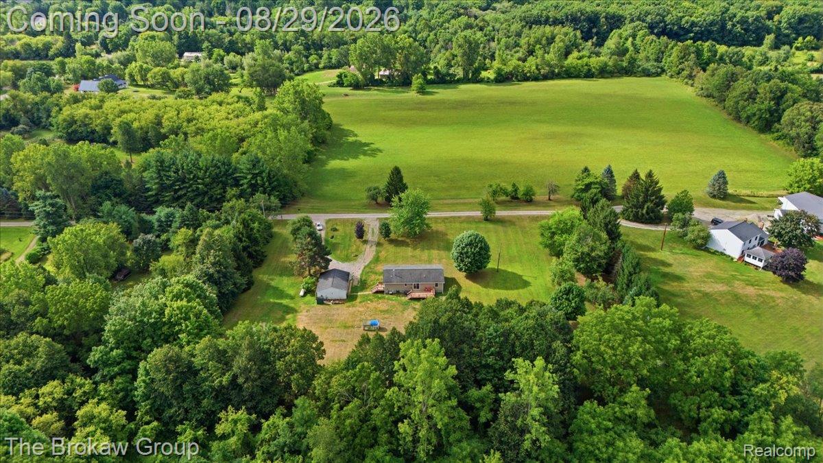 5411 Hess Road Dryden, MI 48428 - Photo 52 of 56 Expansive landscape featuring verdant fields, established trees, and a residential dwelling with an accompanying outbuilding