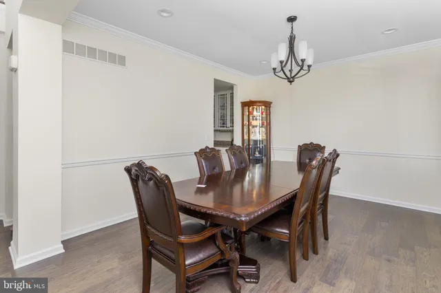 a view of a dining room with furniture a chandelier and wooden floor