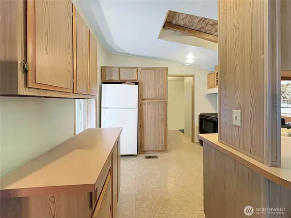 a kitchen with refrigerator and cabinets
