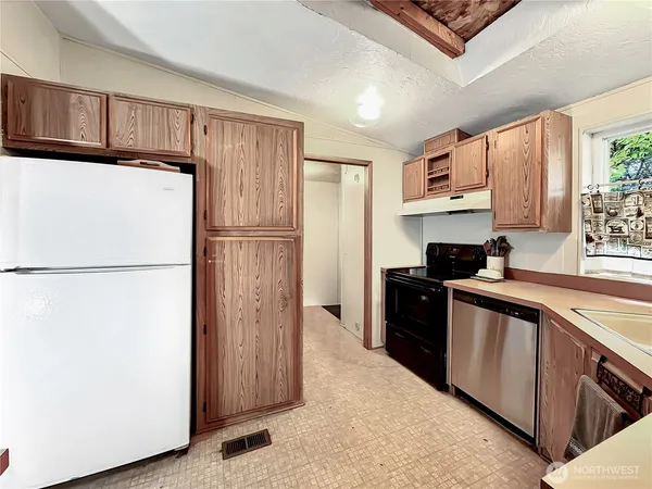 a kitchen with a refrigerator a stove a microwave and cabinets
