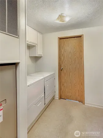 a utility room with cabinets washer and dryer