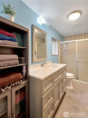a bathroom with a sink a toilet and a shower