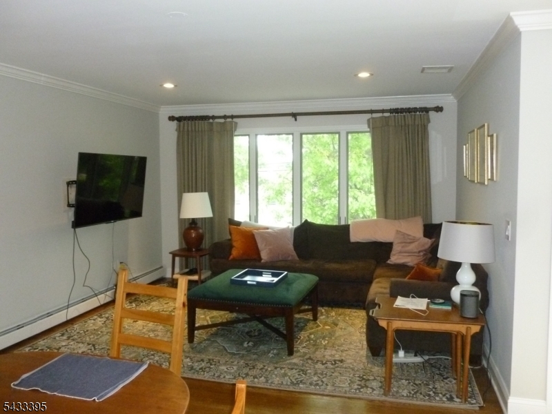 48 Woodmont Road Montclair, NJ 07043 - Photo 6 of 20 a living room with furniture a flat screen tv and a large window