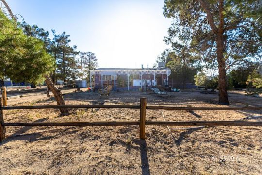 1142 South Guam Street Ridgecrest, CA 93555 - Photo 2 of 16 a view of a house with trees in the background