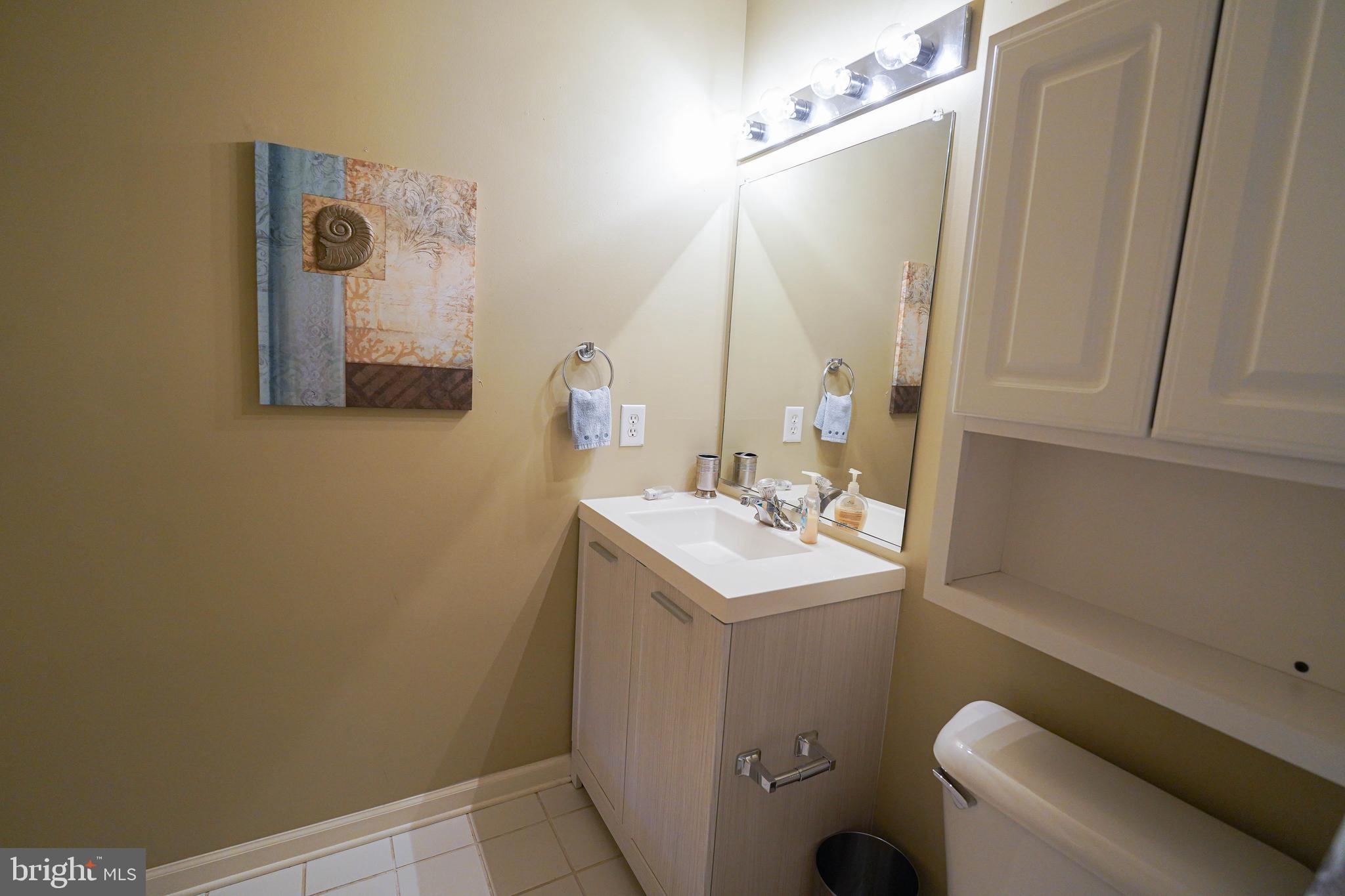 37182 Harbor Drive, Unit 264 Ocean View, DE 19970 - Photo 39 of 55 a bathroom with a sink a toilet and mirror
